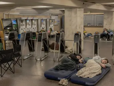 Orang-orang berlindung di stasiun metro selama serangan udara Rusia di Kyiv pada 21 Agustus 2025, di tengah invasi Rusia ke Ukraina. (Roman PILIPEY/AFP)