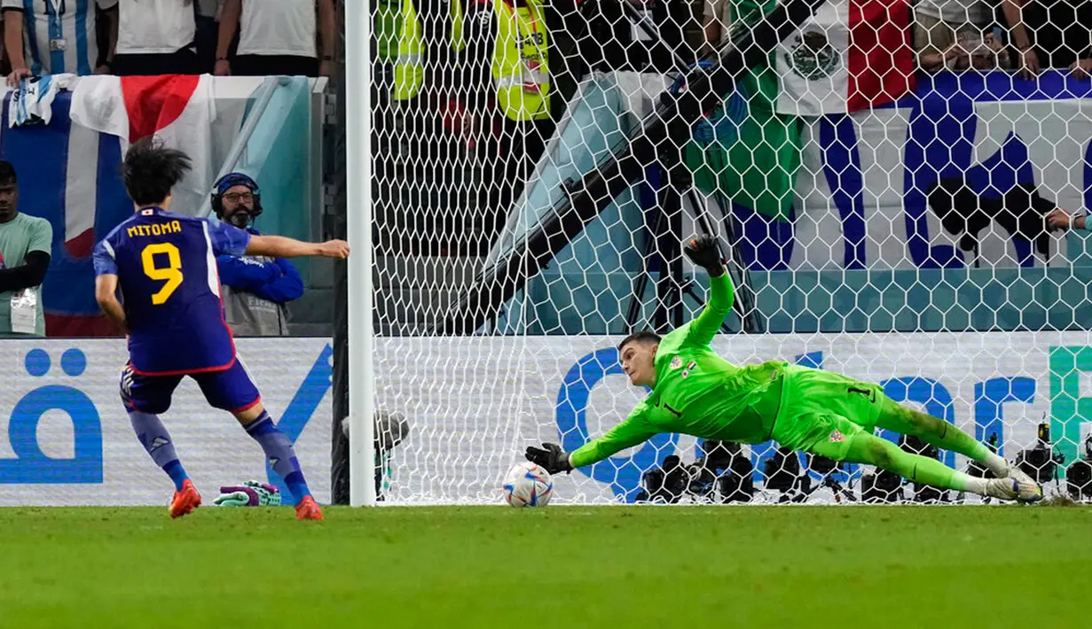Kiper Kroasia Dominik Livakovic menyelamatkan tendangan penalti pemain Jepang Kaoru Mitoma pada pertandingan sepak bola babak 16 besar Piala Dunia 2022 di Stadion Al Janoub, Al Wakrah, Qatar, 5 Desember 2022. Jepang gagal memecahkan rekor menembus perempat final Piala Dunia 2022 usai disingkirkan Kroasia lewat adu penalti 1-3. (AP Photo/Eugene Hoshiko)