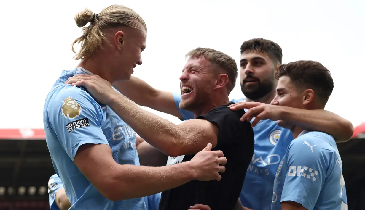 Flanagan langsung diamankan petugas setelah memeluk Erling Haaland dan kemudian dilepaskan usai pertandingan. (Photo by Darren Staples / AFP)