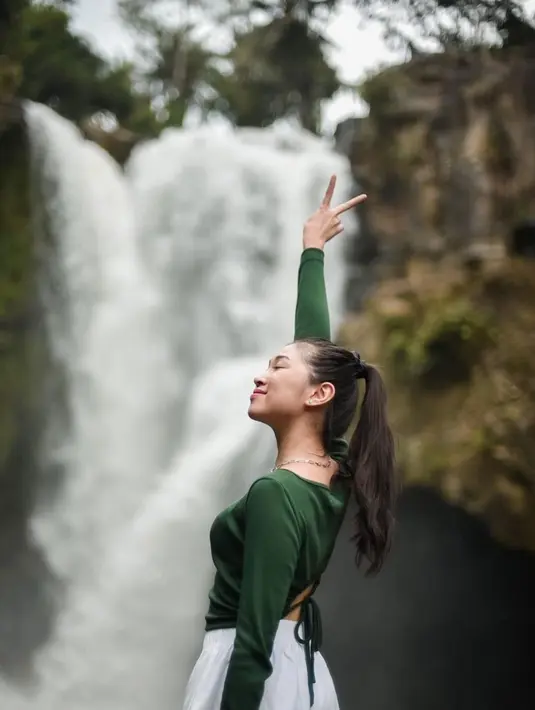 Gaya Shani JKT48 ketika menikmati suasana syahdu di alam bebas ini mencuri perhatian. Ia memakai kaus hitam dan tampak sangat senang di air terjun. Gaya penampilan simpel tapi menawan dari Shani JKT48 ini sukses bikin para penggemarnya terpesona. (Liputan6.com/IG/@jkt48shani)