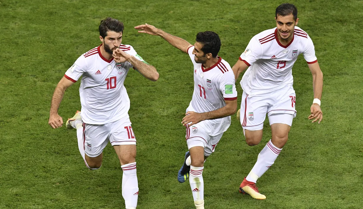 Para pemain Iran merayakan gol yang dicetak Karim Ansarifard ke gawang Portugal pada laga grup B Piala Dunia di Saransk, Senin (25/6/2018). Gol ini tercipta pada menit ‘90+3 atau masa injury time. (AFP/Mladen Antonov)