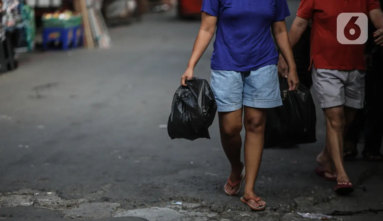 Warga membawa barang belanjaan dengan menggunakan kantong plastik di Kawasan Pasar Jatinegara, Jakarta, Selasa (30/6/2020). Pemerintah Provinsi DKI Jakarta bakal resmi menerapkan larangan penggunaan kantong plastik sekali pakai mulai Rabu, 1 Juli 2020 besok. (Liputan6.com/Faizal Fanani)