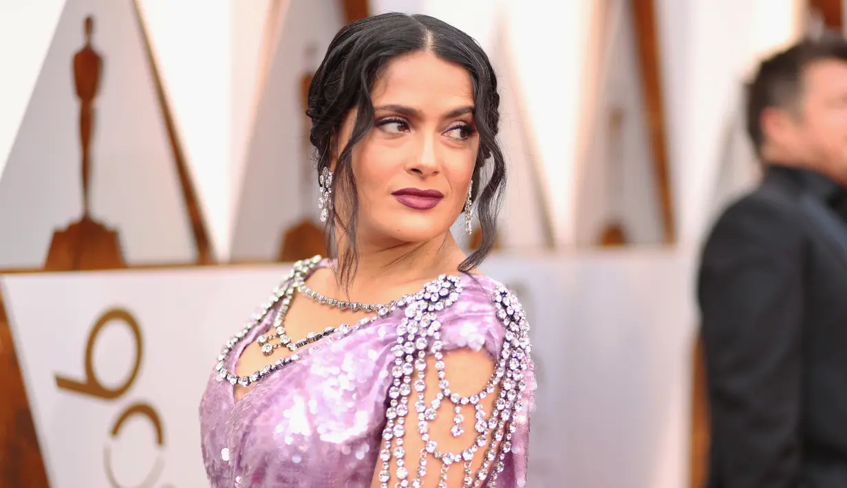 Aktris Salma Hayek ikut ambil bagian pada malam penghargaan Piala Oscar 2018 di Dolby Theatre, Los Angeles, Minggu (4/3). Gaun Salma Hayek tersebut dipercantik dengan berlian yang menjuntai dari bagian bahu. (Christopher Polk/GETTY IMAGES/AFP)