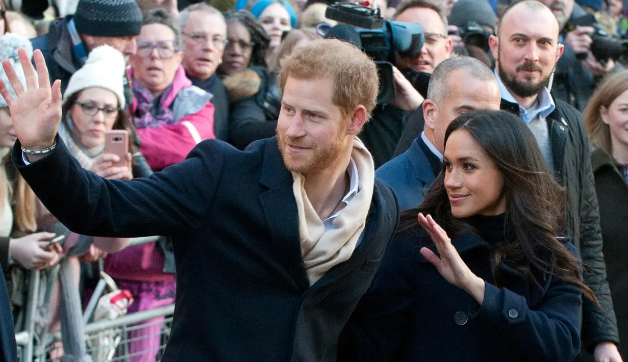 Pangeran Harry dan tunangannya, Meghan Markle melambaikan tangan setibanya di Nottingham Contemporary, Inggris, Jumat (1/12). Mereka mengunjungi Nottingham Contemporary untuk menghadiri acara amal Terrence Higgins Trust World AIDS Day. (AP/Frank Augstein)