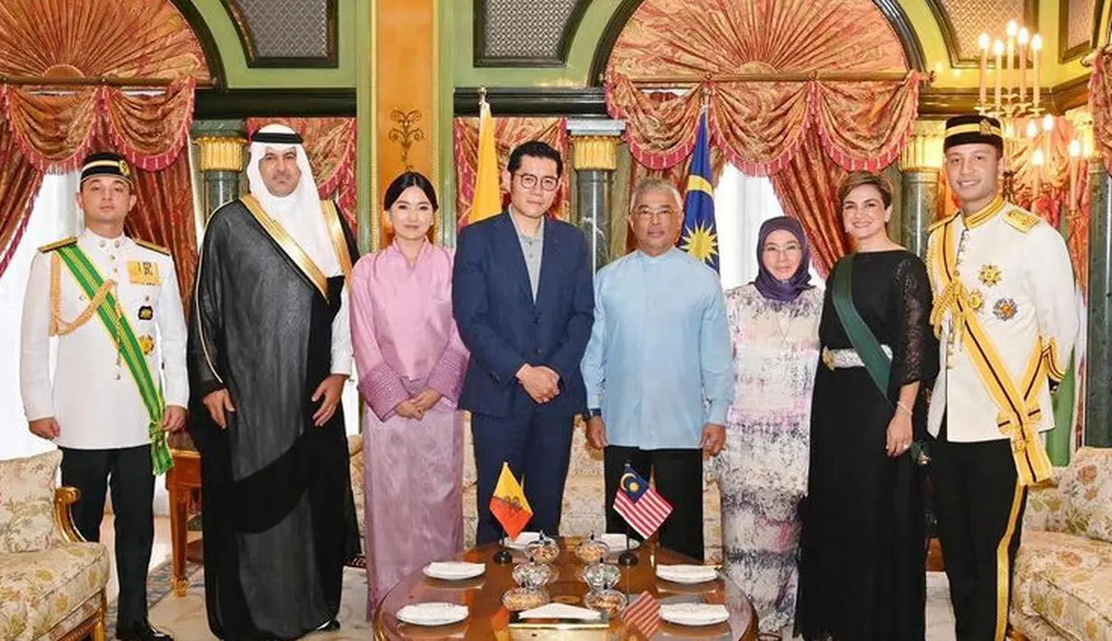 Dengan gaya rambut sanggul tanpa poni, dan riasan flawlessnya. Serta anting-anting minimalis. Sementara sang raja mengenakan setelan jas navy. [@istana_negara]