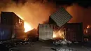 Sejumlah kontainer terbakar setelah serangan udara Israel di Pelabuhan Latakia, Suriah, 28 Desember 2021. Serangan udara Israel terhadap Pelabuhan Latakia menyebabkan kerusakan material yang signifikan dan kebakaran. (SANA/AFP)