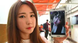 Personel girlband Six Bomb, Lee So-Young atau Seul-Bee, menunjukkan foto dirinya sebelum menjalani operasi plastik di sebuah salon kecantikan di Seoul, Korsel, 16 Maret 2017. Seul-Bee menjalani operasi plastik pada bagian hidungnya. (YELIM LEE/AFP)