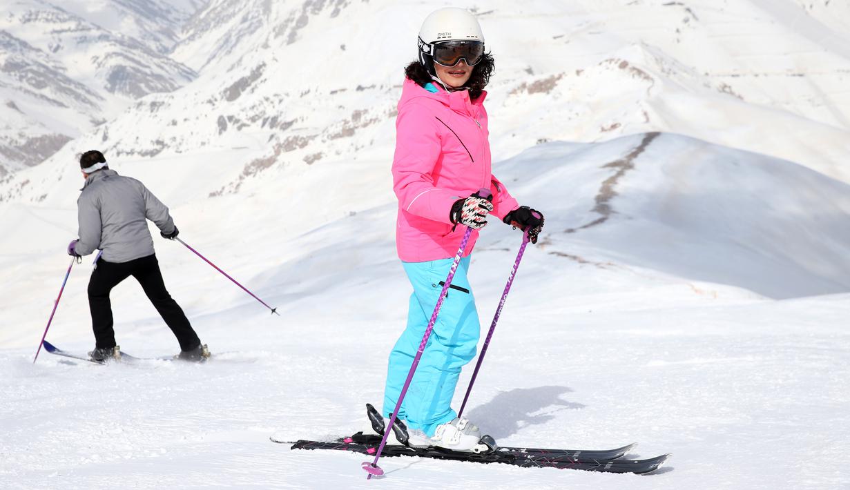 Pemain ski wanita bersiap menuruni lereng di resor ski Dizin, utara ibu kota Tehran, Iran, Kamis (8/3). Setiap tahunnya ribuan wisatawan lokal maupun asing menikmati bermain ski di resor yang termasuk 40 resor tertinggi di dunia. (AP Photo/Vahid Salemi)