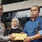 Orangtua Mahasiswa UI Hasya, Adi Syaputra dan Dwi Syafiera Putri, menerima surat pencabutan status tersangka terhadap putranya yang menjadi korban kecelakaan, dari Direktur Lalu Lintas Polda Metro Jaya, Kombes Latif Usman. (Liputan6.com/Ady Anugrahadi)