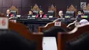 Hakim Mahkamah Konstitusi, I Dewa Gede Palguna (tengah) membacakan nota putusan perkara pengujian undang-undang tentang ASN, Sistem Pendidikan Nasional, Pendidikan dan Gelar Profesi, di Gedung MK, Jakarta, Kamis (14/2). (Liputan6.com/Helmi Fithriansyah)