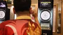 Pemain darts Indonesia Tirta Suparjo mencoba salah satu alat di acara peluncuran Darts Station di lantai F7 FX Sudirman, Senayan, Jakarta pada Sabtu (15/11/2025). (Bola.com/Abdul Aziz)