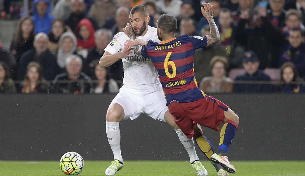 Striker Real Madrid, Karim Benzema, berusaha melewati bek Barcelona, Dani Alves, pada laga La Liga di Stadion Camp Nou, Barcelona, Minggu (3/4/2016) dini hari WIB. Barcelona takluk 1-2 dari Real Madrid. (AFP/Josep Lago)