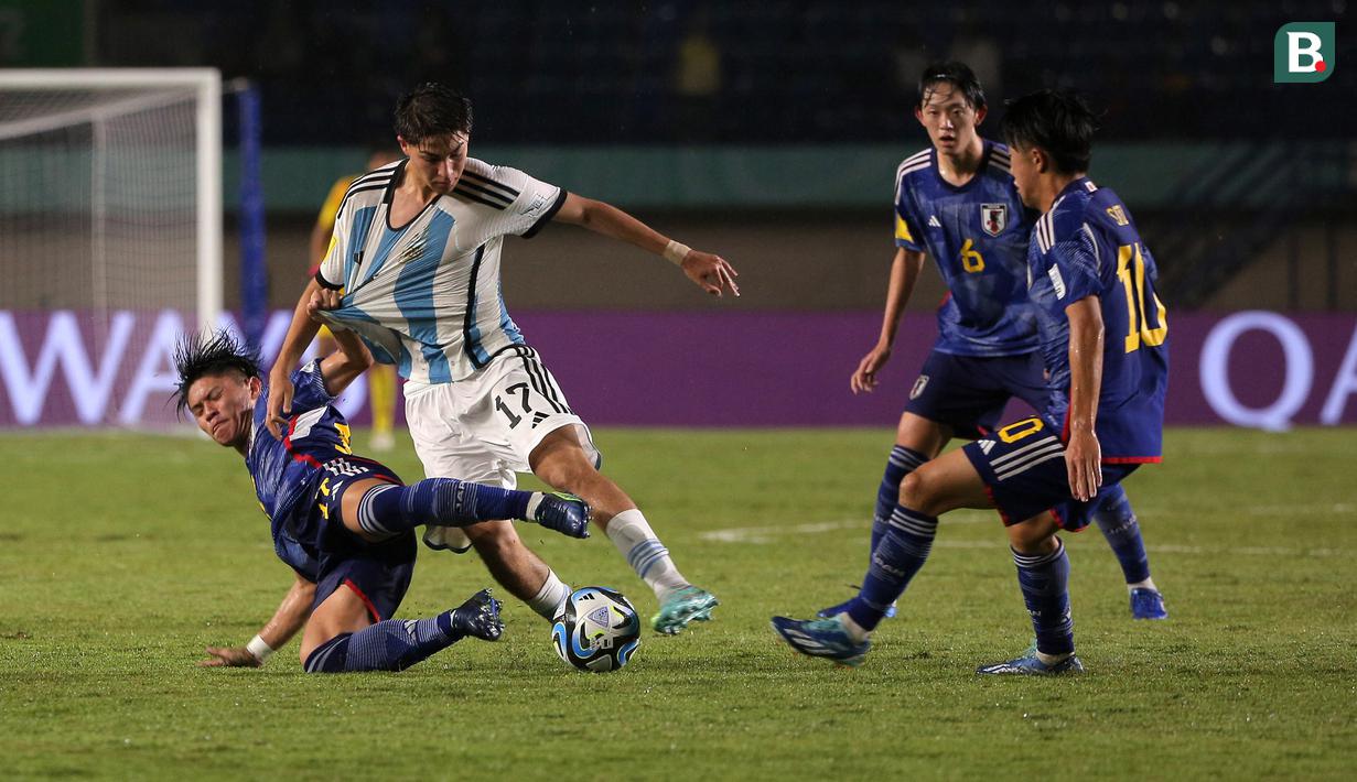 <p>Pemain Timnas Jepang U-17, Shotari Shibata (kiri) berebut bola dengan pemain Timnas Argentina U-17, Valentino Acuna pada laga kedua Grup D Piala Dunia U-17 2023 di Stadion Si Jalak Harupat, Kabupaten Bandung, Selasa (14/11/2023). (Bola.com/Ikhwan Yanuar)</p>