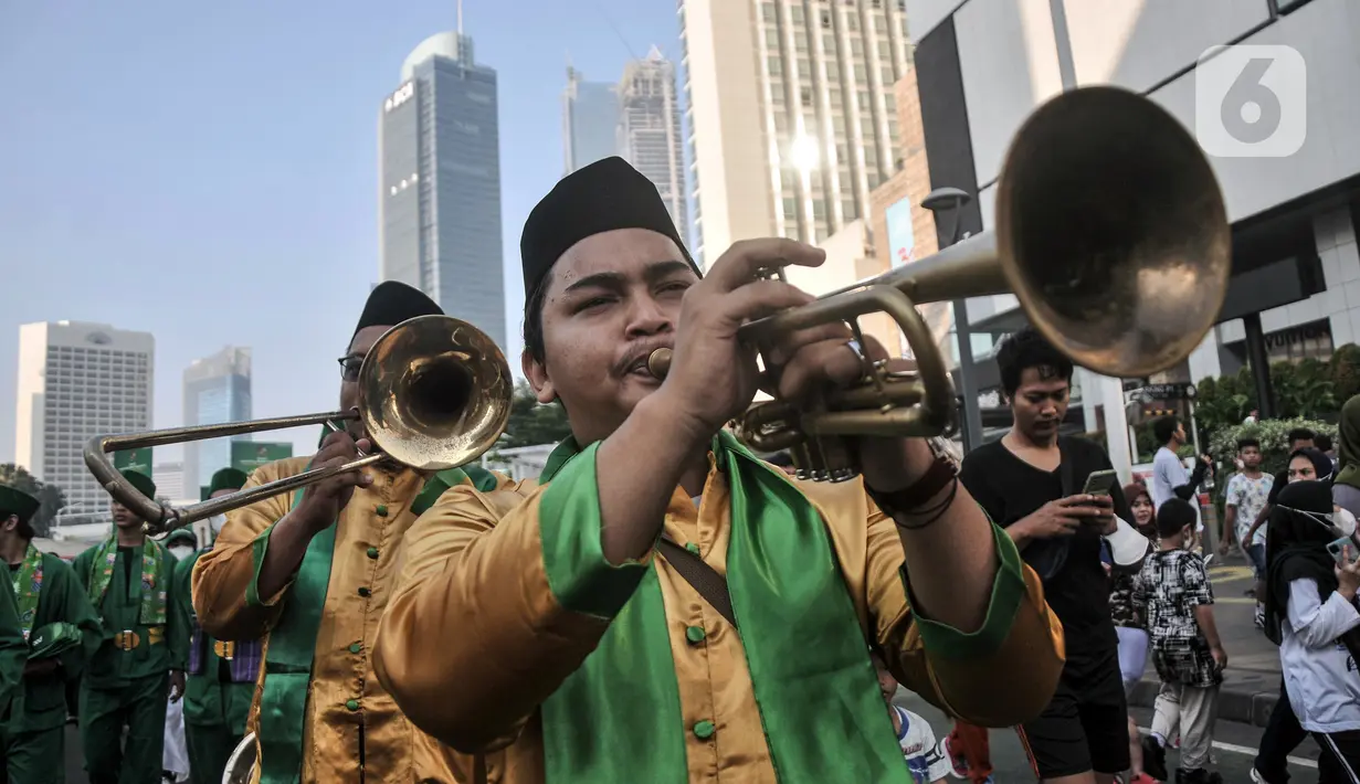 Kesenian Betawi tampil dalam pawai kesenian saat Hari Bebas Kendaraan Bermotor (HBKB) atau car free day (CFD) di Jalan MH Thamrin, Jakarta, Minggu (19/6/2022). Pawai yang menampilkan berbagai budaya dan kesenian Betawi seperti ondel-ondel, tari topeng, serta tanjidor tersebut digelar dalam rangka menyambut HUT ke-495 DKI Jakarta. (merdeka.com/Iqbal S. Nugroho)