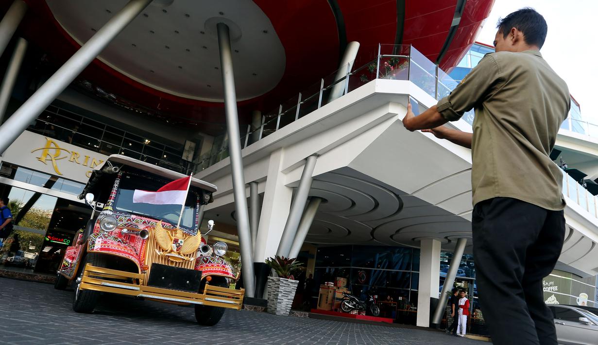 Seorang pria mengambil foto mobil bercorak Ulos Mandailing yang akan digunakan acara ngunduh mantu Kahiyang-Bobby di Medan, Senin (20/11). (Liputan6.com/JohanTallo)