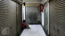 Seorang wanita duduk di antara ruko yang tutup di kawasan Glodok, Jakarta Barat, Jumat (4/11). Khawatir jadi sasaran anarkisme para pendemo, pedagang di kawasan Glodok memilih libur dan menutup toko. (Liputan6.com/Gempur M Surya)