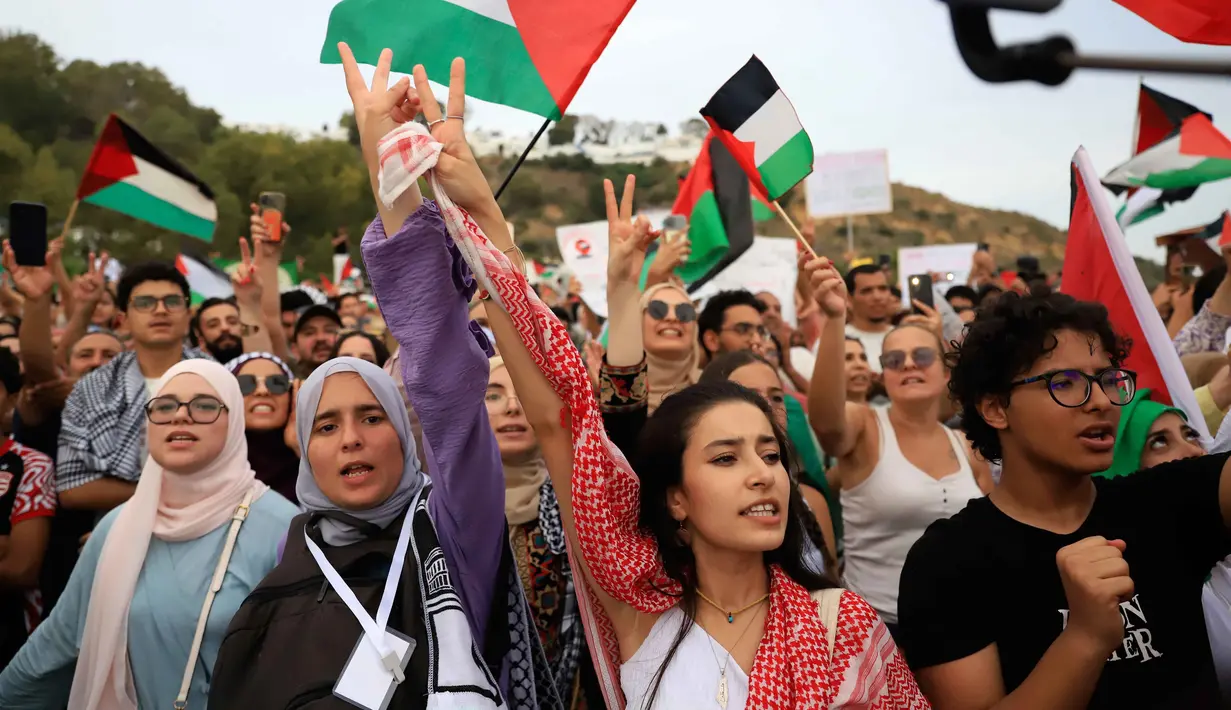 Para aktivis bernyanyi memberikan dukungan kepada konvoi Global Sumud Flotilla saat tiba di pelabuhan Sidi Bou Said, Tunis, Tunisia, pada Minggu 7 September 2025. (AP Photo/Anis Mili)