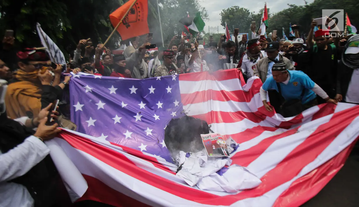 Massa aksi melakukan unjuk rasa dengan membakar bendera Amerika Serikat (AS) di depan Kedubes AS, Jakarta, Senin (11/12). Massa dari berbagai organisasi masyarakat itu juga menuntut agar Duta Besar AS hengkang dari Indonesia. (Liputan6.com/Faizal Fanani)