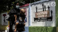 Warga berjalan dekat mural imbauan untuk mematuhi protokol kesehatan di Jakarta, Selasa (20/7/2021). Kementerian Kesehatan mencatat pasien COVID-19 di Jakarta yang sembuh pada 19 Juli 2021 sebanyak 12.674 atau meningkat dibandingkan 18 Juli 2021 sebanyak 11.857 orang. (Liputan6.com/Johan Tallo)