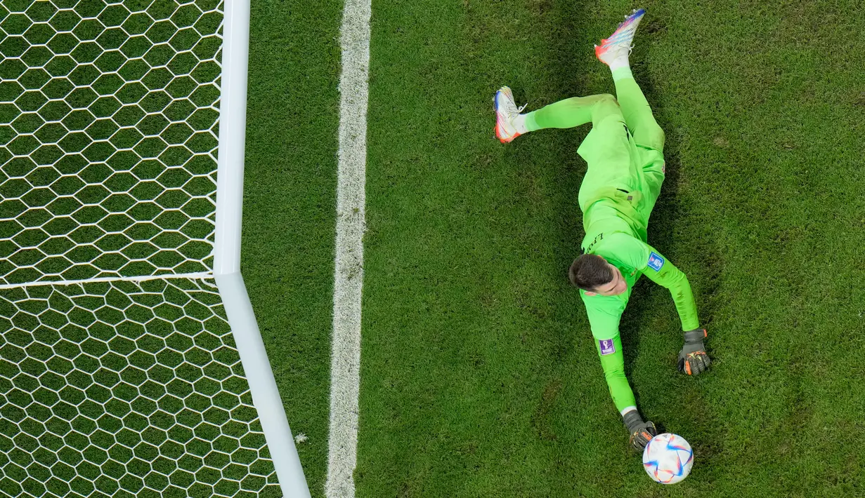 Kiper Kroasia Dominik Livakovic melakukan penyelamatan tendangan penalti pemain Jepang Kaoru Mitoma pada pertandingan sepak bola babak 16 besar Piala Dunia 2022 di Stadion Al Janoub, Al Wakrah, Qatar, 5 Desember 2022. Jepang gagal memecahkan rekor menembus perempat final Piala Dunia 2022 usai disingkirkan Kroasia lewat adu penalti 1-3. (AP Photo/Hassan Ammar)