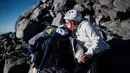 Penyintas kanker Carla Boheme (kiri) dicium oleh saudara perempuannya, Marie Boheme saat mendaki gunung berapi Pico de Orizaba dalam sebuah ekspedisi di Puebla, Meksiko, pada tanggal 24 November 2023. (Rodrigo Oropeza/AFP)