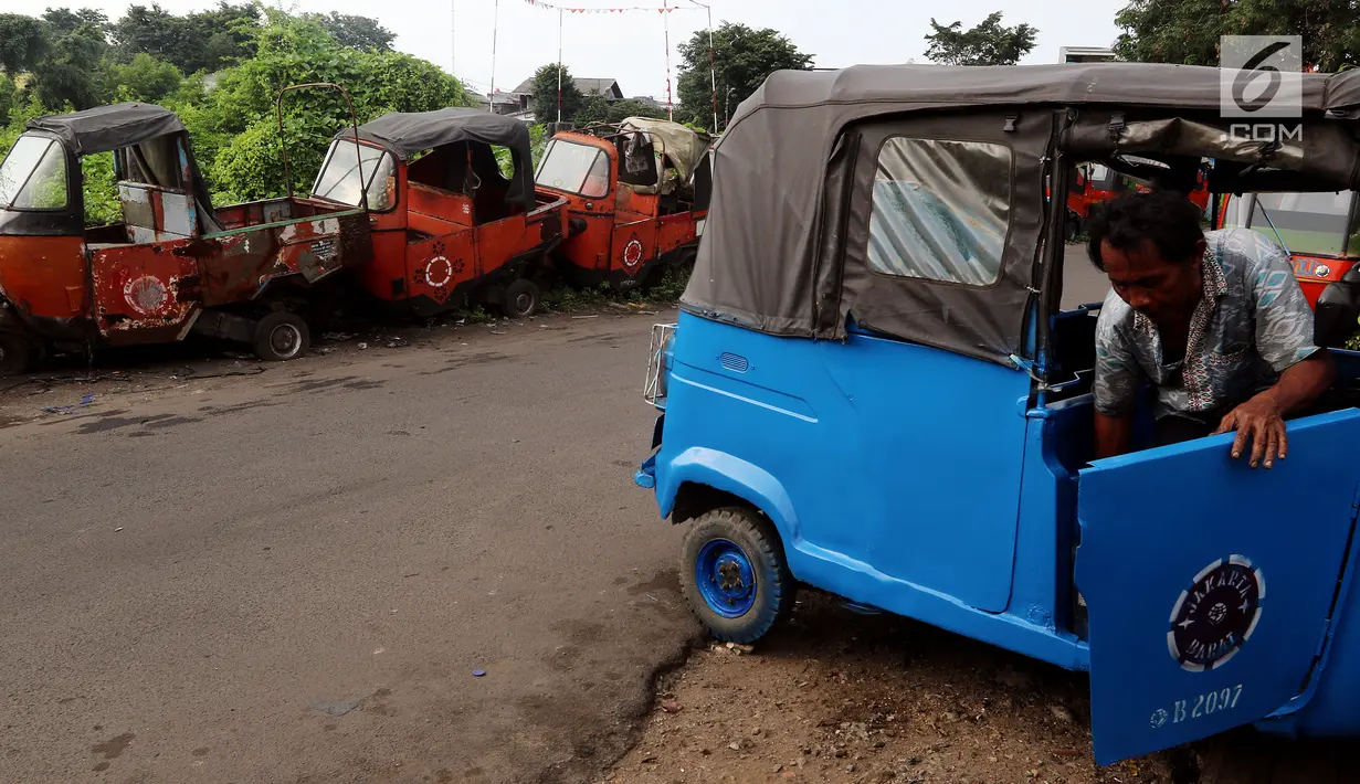 Bangkai bajaj oranye berdampingan dengan bajaj biru tampak terparkir di kawasan Roxy, Jakarta Barat, Selasa (27/2). Bajaj oranye dengan warna dan suara yang khas ini sudah tak lagi digunakan. (Liputan6.com/JohanTallo)