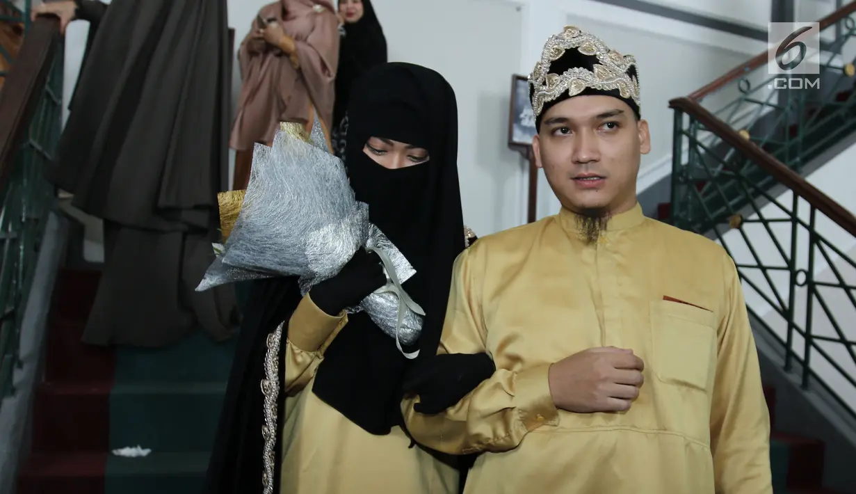 Pesinetron Egi John menggandeng istrinya, Kamilia Yasmin usai malangsungkan pernikahan di kawasan Cinere, Jakarta, Sabtu (1/7). Egi akhirnya resmi melepas status duda dan menikah untuk kedua kalinya dengan Kamilia Yasmin. (Liputan6.com/Herman Zakharia)