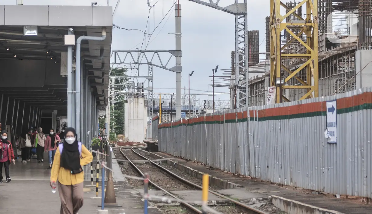 Calon penumpang kereta listrik Commuterline (KRL) saat melintas di dekat proyek pembangunan Stasiun Manggarai, Jakarta, Rabu (22/2/2023). Stasiun Manggarai nantinya akan menjadi stasiun antarmoda yang terintegrasi dengan LRT, Transjakarta dan transportasi umum lainnya serta melayani KA Bandara dan nantinya Kereta Jarak Jauh. (merdeka.com/Iqbal S Nugroho)
