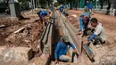 Sejumlah pekerja menyelesaikan pembuatan saluran air di Jalan Asia Afrika, Senayan, Jakarta, Rabu (5/4). Saluran yang sempat tidak berfungsi tersebut di normalisasikan dengan kedalaman 150cm Lebar 100cm dan panjang 195m. (Liputan6.com/Gempur M Surya)