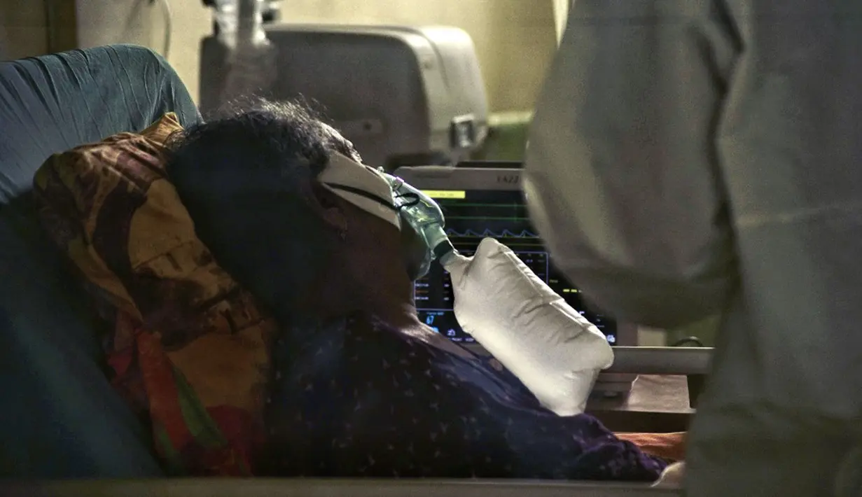 Seorang pasien virus corona COVID-19 terlihat menggunakan oksigen di unit perawatan intensif (ICU) di sebuah rumah sakit di Lhokseumawe, Aceh, Selasa (7/7/2021). Indonesia memperluas pembatasan untuk memerangi gelombang virus corona COVID-19 yang mematikan. (Azwar Ipank/AFP)