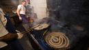 Karyawan menggoreng donat khas Spanyol atau churros dalam minyak panas di restoran dessert tradisional La Manueta, Pamplona, Spanyol, Rabu (10/7/2019). Pastri ringan dan renyah ini cukup populer di daratan Eropa sebagai menu sarapan. (JAIME REINA/AFP)