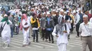 Puluhan orang berjalan kaki menuju Monas dari arah Tanah Abang, Jakarta, Jumat (2/12). Mereka terlihat berbondong-bondong berjalan untuk mengikuti demo 2 Desember di Lapangan Monas. (Liputan6.com/Helmi Afandi)