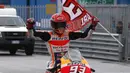 Marc Marquez nenbawa bendera usai tampil sebagai juara pada balapan MotoGP San Mariono di Sikuit Marco Simoncelli, Misano Adriatico, Italia (10/9/2017). (AP/Antonio Calanni)