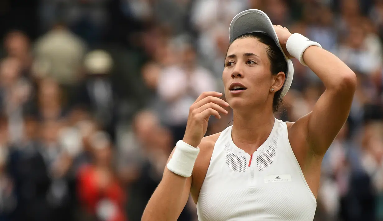 Petenis Spanyol, Garbine Muguruza merapikan topinya usai final turnamen grand slam Wimbledon di London, Sabtu (15/7). Muguruza berhasil menjuarai Wimbledon 2017 setelah meraih kemenangan atas petenis AS Venus Williams. (David Ramos/Pool Photo via AP)