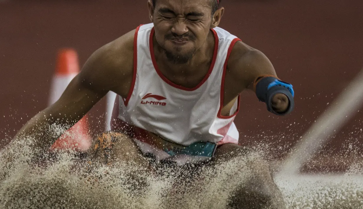Atlet lompat jauh Indonesia, Settiyo Budi Hartanto, melakukan lompatan saat tampil pada cabang atletik nomor lompat jauh  T 45/46/47 Asian Para Games di SUGBK, Jakarta, Senin (8/10/2018). (Bola.com/Vitalis Yogi Trisna)