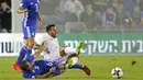 Gelandang Spanyol, Jonathan Viera, dijatuhkan gelandang Israel, Bibras Natcho, pada laga kualifikasi Piala Dunia 2018 di Stadion Teddy, Yerusalem,Senin (9/10/2017). Israel kalah 0-1 dari Spanyol. (AFP/Jack Guez)