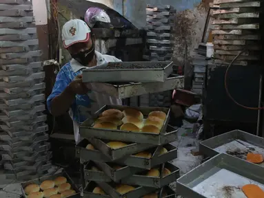 Pekerja menyelesaikan pembuatan roti skala rumahan di kawasan Bendungan Hilir, Jakarta, Selasa (22/6/2021). Menteri Koordinator Perekonomian Airlangga Hartarto mencatat realisasi penyaluran Kredit Usaha Rakyat (KUR) mencapai Rp111,99 triliun hingga 14 Juni 2021. (Liputan6.com/Angga Yuniar)