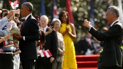 PM Singapura, Lee Hsien Loong mengambil gambar sementara Presiden AS, Barack Obama menyapa warga pada upacara penyambutan kedatangan PM Lee di Gedung Putih, Washington, Selasa (2/8). (REUTERS/ Jonathan Ernst)