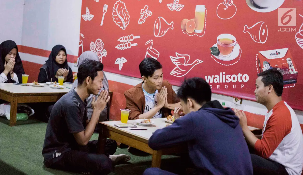 Pengunjung berdoa sebelum menyantap hidangan di Kedai Soto Kauman Express Sawangan, Depok, Jawa Barat, Senin (13/5). Selama Ramadan, kedai soto ini menyediakan satu paket menu buka puasa yang cukup dibayar dengan doa pada secarik kertas. (Liputan6.com/Immanuel Antonius)