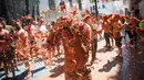 Seorang peserta bersuka ria dengan tomat yang hancur saat berpartisipasi dalam festival tahunan "Tomatina" di Bunol, salah satu kota di timur Spanyol, Rabu (29/8/2019). Perang tomat yang penuh kehebohan itu rutin diadakan setiap Rabu terakhir bulan Agustus. (JAIME REINA / AFP)