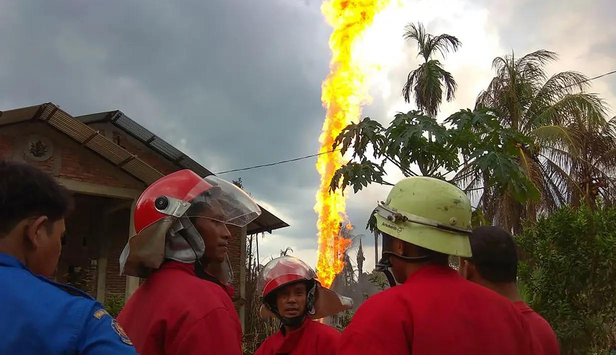 Petugas pemadam kebakaran berada di lokasi kebakaran pengeboran sumur minyak ilegal milik warga di Peureulak, Provinsi Aceh, Rabu (25/4). Ledakan diduga terjadi saat berlangsungnya penggalian untuk menyedot minyak mentah dari perut bumi (ILYAS ISMAIL/AFP)