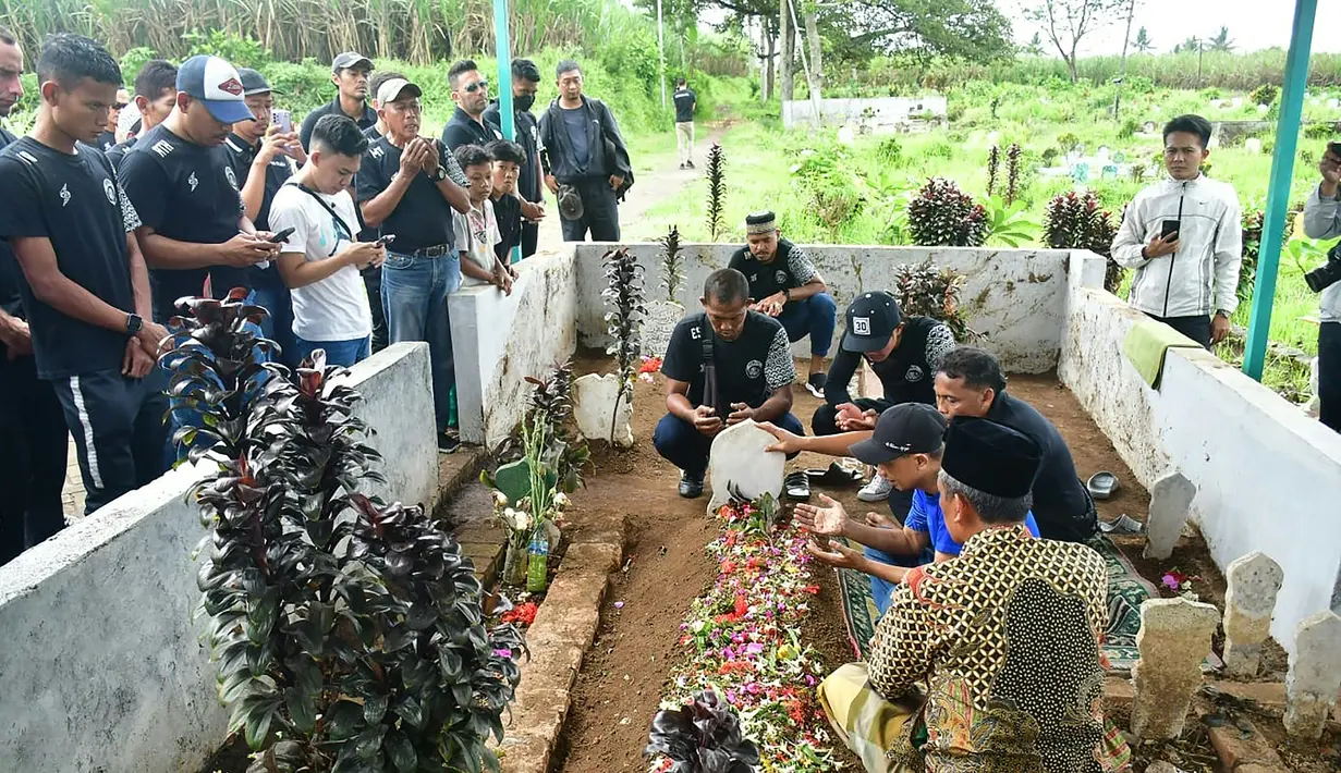 Arema FC menjadi klub yang paling berduka atas Tragedi Kanjuruhan yang menewaskan ratusan korban jiwa yang sebagian besar merupakan fans fanatik mereka. Berbagai empati pun dilakukan skuad Arema FC untuk memberi penghormatan kepada mereka yang menjadi korban dan memberi kekuatan bagi keluarga korban. Usai melakukan tabur bunga di Stadion Kanjuruhan, para pemain dan ofisial tim Arema FC pun melakukan ziarah ke makam salah satu korban, Senin (3/10/2022). (AFP/Putri)