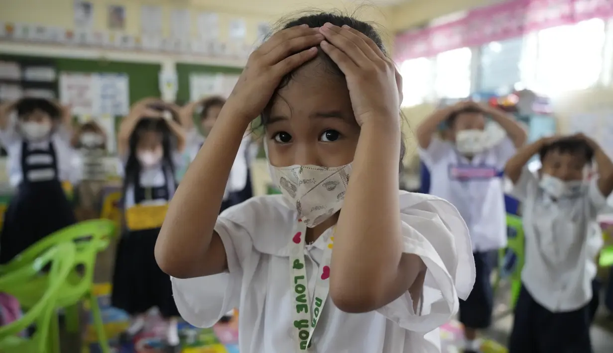 <p>Siswa meletakkan tangan mereka di atas kepala untuk perlindungan selama latihan gempa di sebuah sekolah dasar di Metro Manila, Filipina, Kamis (8/9/2022). Filipina melakukan latihan gempa nasional kuartal ketiga sebagai bagian dari upaya untuk membuat publik mengetahui protokol dan tanggapan selama bencana. (AP Photo/Aaron Favila)</p>