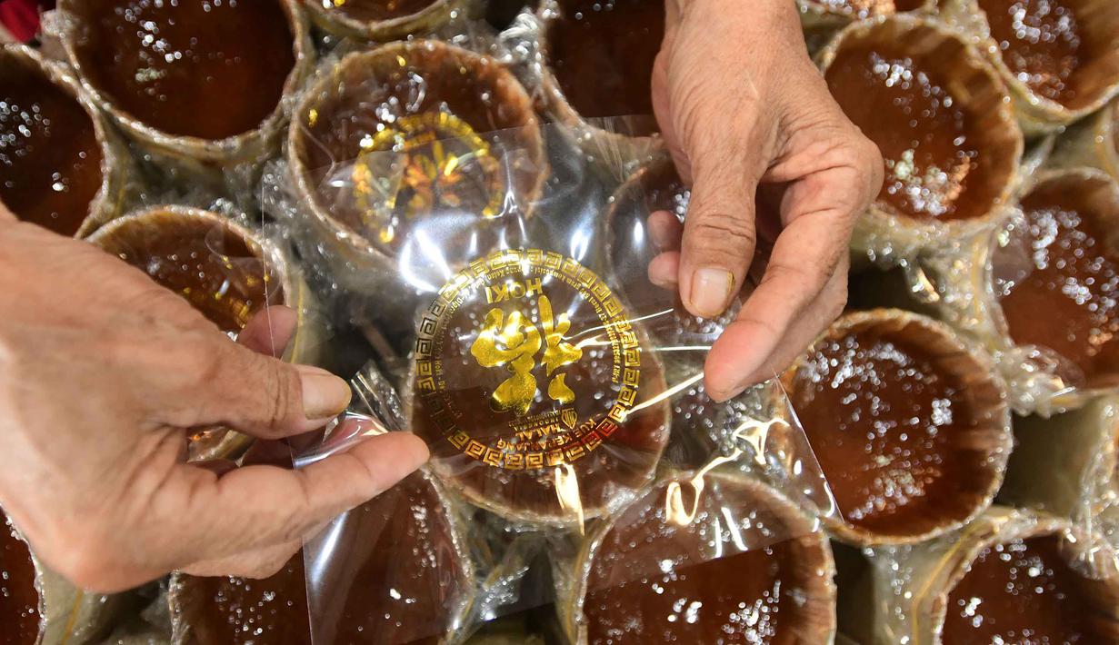 Kue ini juga sering disebut sebagai Dodol Cina. Kue ini bukan sekadar hidangan, melainkan simbol harapan dan doa bagi masyarakat keturunan Tionghoa di Indonesia. Tampak dalam foto, pekerja menyelesaikan pembuatan kue keranjang di Pabrik Kue Hoki, kawasan Sawangan, Depok, Jawa Barat, Rabu (11/2/2025). (merdeka.com/Arie Basuki)