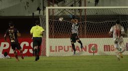 Kiper Persija Jakarta, Andritany Ardhiyasa (tengah) berusaha menangkap bola hasil tendangan pemain PSM Makassar dalam laga leg pertama semifinal Piala Menpora 2021 di Stadion Maguwoharjo, Sleman, Kamis (15/4/2021). (Bola.com/Ikhwan Yanuar)