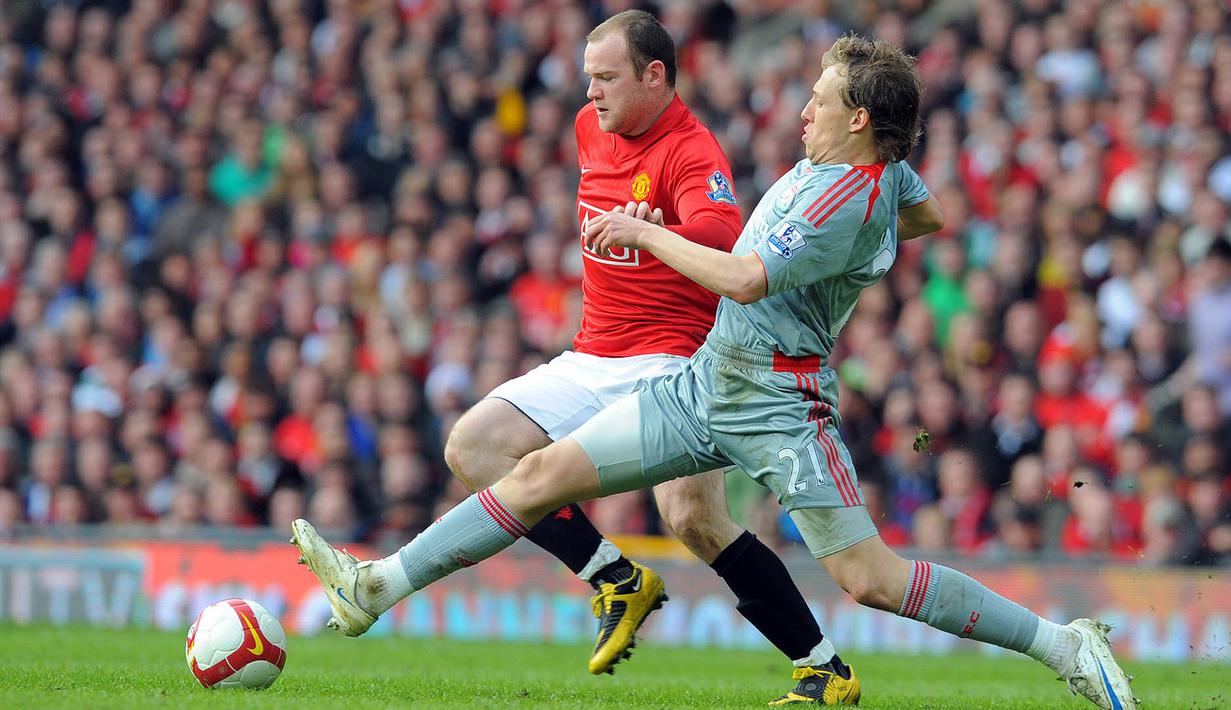 Striker Manchester United, Wayne Rooney, berusaha melewati gelandang Liverpool, Lucas Leiva. Bermain sebagai tuan rumah, MU tampil menyerang dan sempat unggul 1-0 melalui gol Cristiano Ronaldo. (AFP/Andrew Yates)