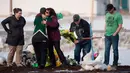 Keluarga dan kerabat menaruh bunga di lokasi kecelakaan bus yang membawa tim hoki es Humboldt Broncos di Provinsi Saskatchewan, Kanada (9/4). Sebanyak 14 orang tewas dalam kecelakaan tersebut. (Jonathan Hayward/The Canadian Press via AP)