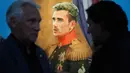 Pengunjung berbincang dekat lukisan bintang sepak bola Prancis, Antoine Griezmann pada Piala Dunia 2018 di Museum of Academy of Arts, Saint Petersburg, Rabu (20/6). Para bintang sepak bola dunia dilukis layaknya jenderal militer. (AP/Dmitri Lovetsky)