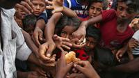Anak-anak etnis Rohingya dari Myanmar merentangkan tangan mereka untuk menerima makanan yang didistribusikan oleh penduduk setempat di Kamp Pengungsian Kutupalong di Cox's Bazar, Bangladesh, 30 Agustus 2017. (AP Photo/Mushfiqul Alam)