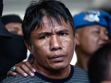 Tersangka kasus perampokan dan pembunuhan di Pulomas, Jakarta Timur, Ridwan Sitorus tiba di Bandara Halim Perdana Kusumah, Minggu (1/1). Ia ditangkap oleh aparat gabungan di sebuah pul bus di Medan, Sumatera Utara. (Liputan6.com/Faizal Fanani)